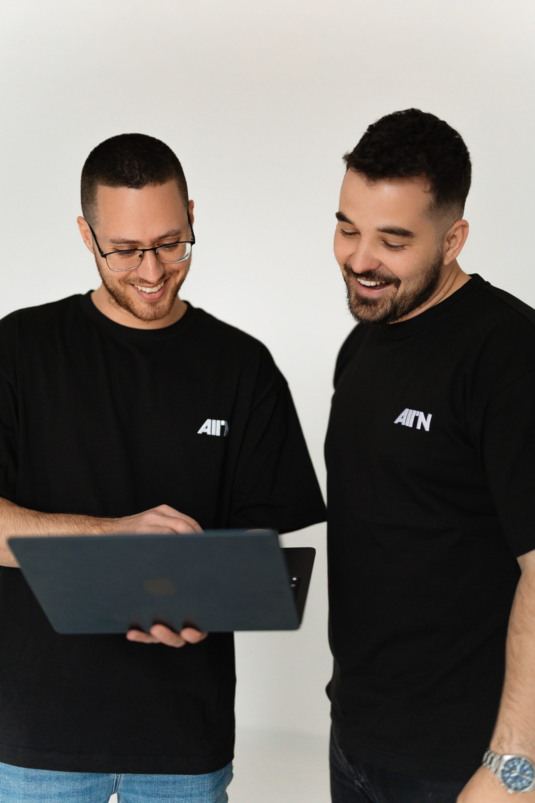 Az ALLIN Agency két munkatársa laptop fölé hajolva egyeztet